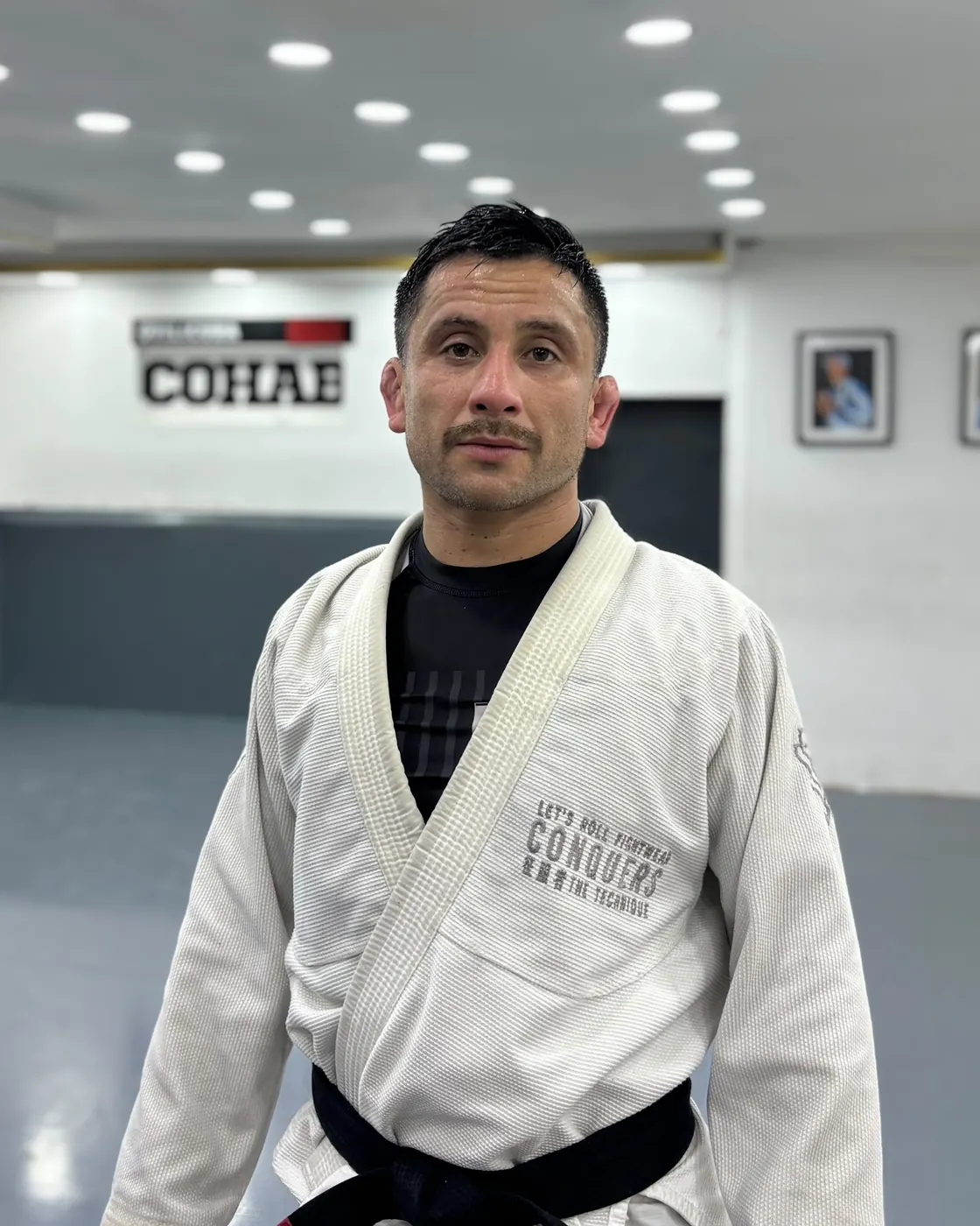 Matías Gálvez, profesor principal de Cohab Quilicura, con kimono blanco y cinturón negro en la academia